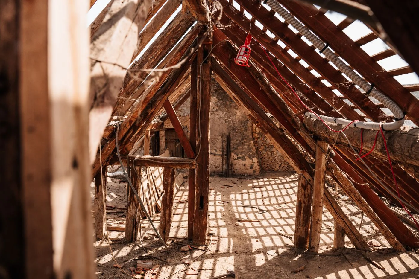 The attic framing of an older home, where cellulose fills tight cavities